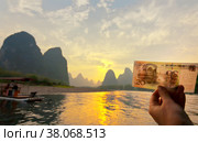 The tourist holds in her hand a bill of 20 yuan which depicts this place on the Li (Lijiang) River with green karst hills. Unusual natural park. Tourism in beautiful places in China (2011 год). Стоковое фото, фотограф Виктория Катьянова / Фотобанк Лори