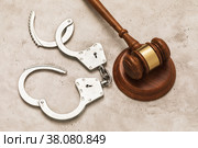 Открытые наручники и судейский молоток на столе, концепция на тему освобождения по решению суда. Стоковое фото, фотограф Сергей Чайко / Фотобанк Лори