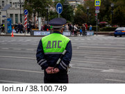 Инспектор ДПС стоит на посту на Тверской улице в центре города Москвы и обеспечивают безопасность движения на дороге, Россия (2022 год). Редакционное фото, фотограф Николай Винокуров / Фотобанк Лори