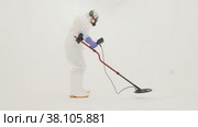 Man in white chemical protection suit holds metal detector. Стоковое видео, видеограф Aleksey Kidisyuk / Фотобанк Лори