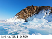 Lake Baikal in winter. One of the most beautiful ice caves on the island Kharantsy, huge icicles and snow-white peels adorn the coastal cliffs, but blue ice hummocks block entrance to the grotto. Стоковое фото, фотограф Виктория Катьянова / Фотобанк Лори