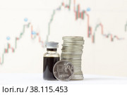 Рублевые монеты и бутылёк сырой нефти на фоне ценового графика. Стоковое фото, фотограф Елена Абдураманова / Фотобанк Лори