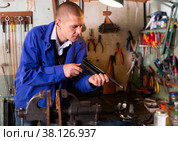 Gunsmith disassembles and repairs pistol in weapons workshop. Стоковое фото, фотограф Яков Филимонов / Фотобанк Лори