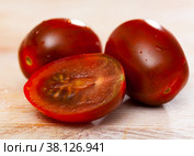 Closeup of fresh cherry kumato tomatoes with chopped slices. Стоковое фото, фотограф Яков Филимонов / Фотобанк Лори