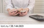 The girl counts money using a calculator the concept of accounting. Стоковое видео, видеограф Катерина Белякина / Фотобанк Лори