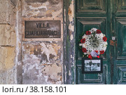 People bring wreaths and flowers to door of villa where the Queen lived in Malta, in connection with her death (2022 год). Редакционное фото, фотограф Kira_Yan / Фотобанк Лори