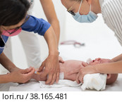 Baby beeing vaccinated by pediatrician in presence of his mother. Preventive vaccination against Diphtheria, whooping cough, tetanus, hepatitis, haemophilus influenzae, pneumococcus, poliomyelitis. Стоковое фото, фотограф Matej Kastelic / Фотобанк Лори