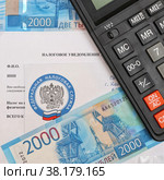 Налоговое уведомление, калькулятор и российские деньги (2022 год). Редакционное фото, фотограф Цибаев Алексей / Фотобанк Лори