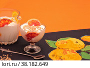 Мороженое. Апельсиновый десерт. Дольки апельсинов, апельсиновая карамель на скатерти с апельсиновым рисунком. Стоковое фото, фотограф Татьяна Бакуменко / Фотобанк Лори