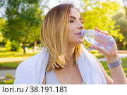 Young beautiful woman drinking water during morning jogging in the park. Стоковое фото, фотограф Сергей Толмачёв / Фотобанк Лори