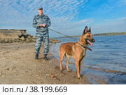 Полицейский с собакой преследует преступника (2022 год). Редакционное фото, фотограф Виталий Михайлюк / Фотобанк Лори