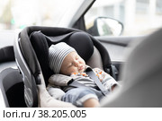 Cute little baby boy sleeping strapped into infant car seat in passenger compartment during car drive. Стоковое фото, фотограф Matej Kastelic / Фотобанк Лори