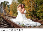 Young cute couple on their honeymoon woman and man embrace in their bed on railway tracks. Concept of romantic travel ban and inability to move. Stay at home. Copying space for a site. Стоковое фото, фотограф Aleksandr Golubev / Фотобанк Лори
