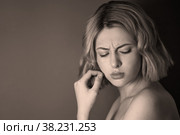 Closeup pretty portrait an angry discontented young woman with finger on lips against dark background. Female shows emotion annoying actress. Concept of adversity and irritation. Copy space for site. Стоковое фото, фотограф Aleksandr Golubev / Фотобанк Лори