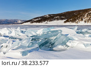 Beautiful winter landscape of frozen Lake Baikal on sunny January day. Snowy ice hummocks with transparent blue piles of ice near the village of Bolshoye Goloustnoye. Natural background. Winter travel. Стоковое фото, фотограф Виктория Катьянова / Фотобанк Лори