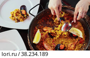 National Spanish dish is paella with seafood, cooked in a pan of rice with saffron, with the addition of the gifts of the sea. Decorated with a slice of lemon. Стоковое видео, видеограф Яков Филимонов / Фотобанк Лори