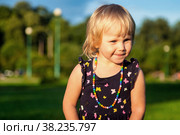 Cute little blond baby girl two year old playing with teddy bear on fresh green grass with flowers. Kid having fun making first steps on mowed natural lawn. Happy and healthy childhood concept. Стоковое фото, фотограф Aleksandr Golubev / Фотобанк Лори