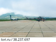 Helicopter and plane at the airport of Kunashir island preparing for takeoff (2022 год). Редакционное фото, фотограф Евгений Харитонов / Фотобанк Лори
