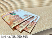 Сложенные купюры 15 тысяч рублей на мебели МДФ. Стоковое фото, фотограф Дарья Смолкина / Фотобанк Лори