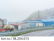 View of the village of Yuzhno-Kurilsk on the island of Kunashir during fog (2022 год). Редакционное фото, фотограф Евгений Харитонов / Фотобанк Лори