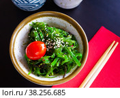 Wakame seaweed salad with sesame seeds and tomato in bowl. Стоковое фото, фотограф Яков Филимонов / Фотобанк Лори