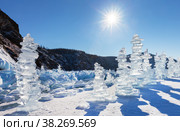 Baikal Lake in winter sunny day. Tourists traditionally build large ice pyramids from transparent ice floes near the famous Khoboy Cape or Deva Rock on Olkhon Island. Winter travel and outdoor recreation. Стоковое фото, фотограф Виктория Катьянова / Фотобанк Лори