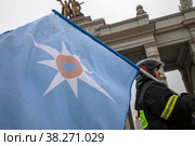 Сотрудница МЧС несет флаг МЧС  во время празднования Дня народного единства на фоне главной арки ВДНХ в городе Москве, Россия (2022 год). Редакционное фото, фотограф Николай Винокуров / Фотобанк Лори