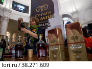 Женщина предлагает посетителям продегустировать коньяк армянский марочный коньяк "Горы и Камни" на фестивале вина и крепких напитков «Armwinefest 2022" в павильоне Армения на ВДНХ в городе Москве, Россия. Редакционное фото, фотограф Николай Винокуров / Фотобанк Лори