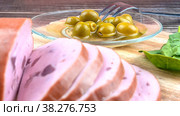 Still life of sliced sausage and olives close-up on a wooden table. Home gastronomy. Стоковое фото, фотограф Ярославский Максим / Фотобанк Лори
