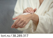 Hands of young woman applies hand skincare cream. Woman model with body cream jar in hands. Winter skin care and wellness concept. Selective focus, copy space. Стоковое фото, фотограф Юлия Тарасова / Фотобанк Лори