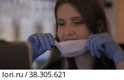 Girl Slavic appearance in medical mask and rubber gloves works with computer-laptop. Стоковое видео, видеограф Aleksandr Golubev / Фотобанк Лори