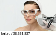 Therapist beautician makes a laser rejuvenation for the model by apparatus in a beauty salon. Стоковое фото, фотограф Юлия Тарасова / Фотобанк Лори