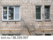 Москва, СВАО, микрорайон Марфино, улица Академика Комарова, 12. Окна на фасаде старого кирпичного дома: два узких и одно широкое. Широкое окно  заваленное коробками (2022 год). Редакционное фото, фотограф Наталья Николаева / Фотобанк Лори