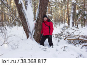 Мужчина шел по заснеженному лесу, устал и прислонился к дереву. Стоковое фото, фотограф Александр Романов / Фотобанк Лори