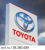 Official dealership sign of Toyota against the blue sky background. Toyota Motor Corporation is a Japanese automotive manufacturer (2016 год). Редакционное фото, фотограф FotograFF / Фотобанк Лори