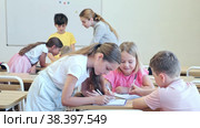 Focused tweens working in small groups during lesson at school, discussing assignment given by teacher. Teamwork concept. Стоковое видео, видеограф Яков Филимонов / Фотобанк Лори