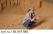 Positive skilled female farmer holding handful of soybean hulls in farm storage. Concept of using natural feed for cattle. Стоковое видео, видеограф Яков Филимонов / Фотобанк Лори