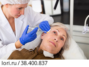 Cosmetologist doing botulotoxin injections for senior woman. Стоковое фото, фотограф Яков Филимонов / Фотобанк Лори