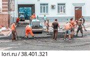 Russia, Samara, July 2017: A team of workers with the help of special equipment is laying asphalt at the entrance to the yard. on a summer day. Text in Russian: Chapaevskaya Street. Редакционное фото, фотограф Акиньшин Владимир / Фотобанк Лори