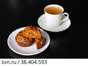 Морковные кексы с грецкими орехами и специями рядом с белой фарфоровой чашкой, в которой налит зелёный чай. Стоковое фото, фотограф Елена Яворская / Фотобанк Лори