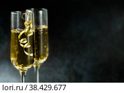С Новым 2023 годом. Фон для рождественских и новогодних праздников с пространством для копирования. Два бокала шампанского с блестящими огнями на темном фоне. Стоковое фото, фотограф Photojuli / Фотобанк Лори