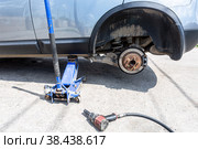 Сar at the tire mounting with removed wheel on pneumatic jack. Стоковое фото, фотограф FotograFF / Фотобанк Лори