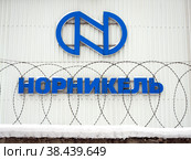Логотип компании Норникель за забором с колючей проволокой (2022 год). Редакционное фото, фотограф Вячеслав Палес / Фотобанк Лори