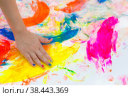 Счастливый веселый грязный ребенок играет с краской на белом фоне. Веселые развивающие игры дома. Грязные руки ребенка крупным планом. Стоковое фото, фотограф Photojuli / Фотобанк Лори