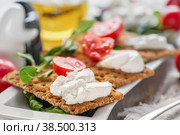 Burato cheese toasts with tomatoes and green salad on a white plate. The concept of healthy eating. Стоковое фото, фотограф Оксана Медведева / Фотобанк Лори