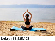 A young girl is doing yoga on a sandy beach. Meditation and rest. Стоковое фото, фотограф Виктория Тельминова / Фотобанк Лори
