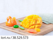 square slices of Alfonso mango lie on a wooden Board ready to eat. Copy of the space. Стоковое фото, фотограф Оксана Медведева / Фотобанк Лори
