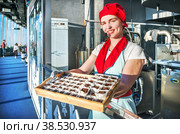 Красивая девушка-экскурсовод на Фабрике Шоколада и шоколадные конфеты, башня Федерация Москва-Сити, Москва (2022 год). Редакционное фото, фотограф Baturina Yuliya / Фотобанк Лори