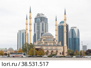 GROZNY, RUSSIA - November 05, 2022: Daily life in Chechen Republic. Main mosque of the Chechen Republic - Akhmad Kadyrov Mosque (Heart of Chechnya) and and skyscrapers of Grozny-city. Редакционное фото, фотограф Ирина Михайличенко / Фотобанк Лори
