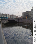 Набережная реки Карповки, в воде отражается фонарь и небо с облаками, через реку перекинут Силин мост (2021 год). Редакционное фото, фотограф Елена Яворская / Фотобанк Лори